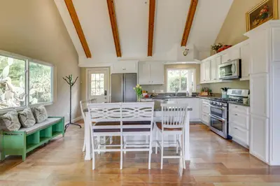 a kitchen with white cabinets and a table and chairs at Hot Tub and Balcony Rainbow Retreat Near Wineries! in Fallbrook