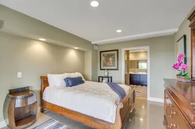 a bedroom with a large bed and a dresser at Hot Tub and Balcony Rainbow Retreat Near Wineries! in Fallbrook