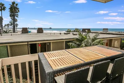 a balcony with a table and chairs and a beach at D108 - Seascape Haven in Oceanside