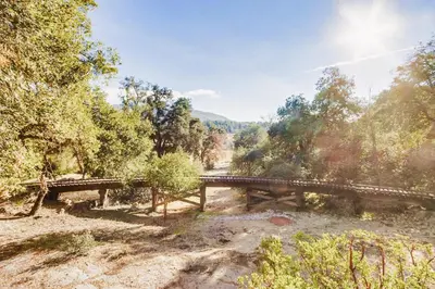 a wooden bridge over a river in a forest at Hot tub Disney train track in Julian amazing views in Julian