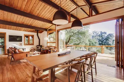 a dining room and living room with a table and chairs at Hot tub Disney train track in Julian amazing views in Julian