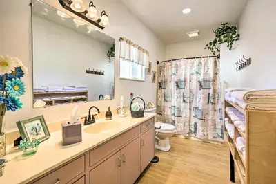 a bathroom with a sink and a toilet and a large mirror at Sunny Bonita Studio about 5 Mi to Historic Dtwn! in Bonita