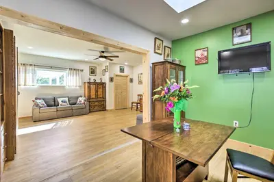 a living room with a vase of flowers on a table at Sunny Bonita Studio about 5 Mi to Historic Dtwn! in Bonita