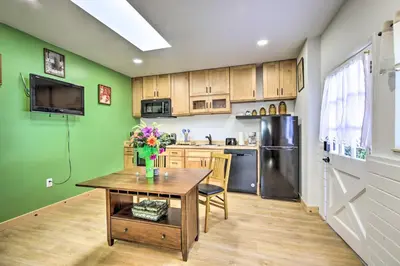a kitchen with green walls and a table with flowers on it at Sunny Bonita Studio about 5 Mi to Historic Dtwn! in Bonita