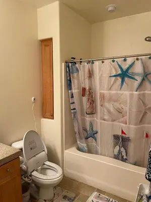 a bathroom with a toilet and a shower curtain at Resort like stay in a lovely room near UCI in Irvine