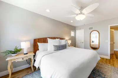 a bedroom with a white bed and a ceiling fan at Walk to Mission Beach Centrally Located Townhome in San Diego