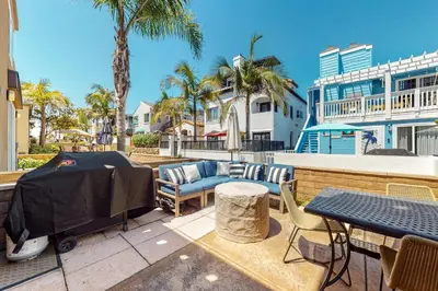 a patio with a table and chairs and palm trees at Walk to Mission Beach Centrally Located Townhome in San Diego