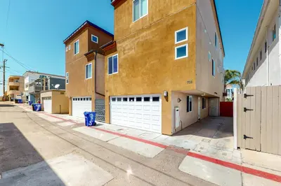 a building with two garages on a street at Walk to Mission Beach Centrally Located Townhome in San Diego