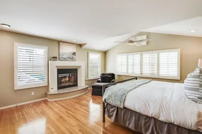 a bedroom with a large bed and a fireplace at Draper Oasis Ocean vVews in San Diego