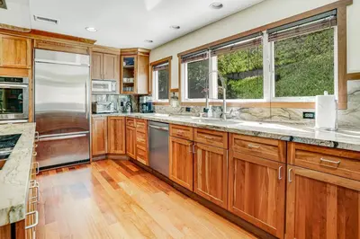 a kitchen with wooden cabinets and stainless steel appliances at Hilcraft Home in Solana Beach