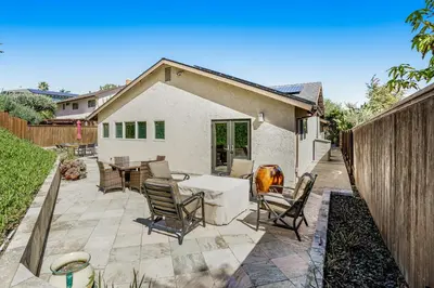 a patio with chairs and a table in a backyard at Hilcraft Home in Solana Beach