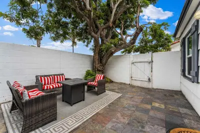 a patio with two chairs and a table and a tree at La Jolla Beach Casita in San Diego