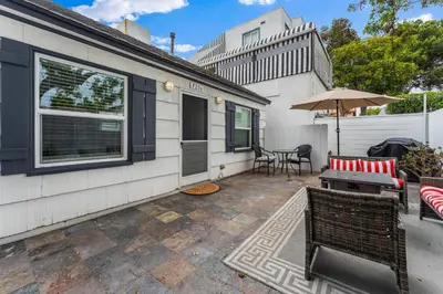 a patio with a table and chairs and an umbrella at La Jolla Beach Casita in San Diego