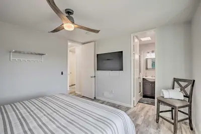 a bedroom with a bed and a ceiling fan at Charming Oceanside Condo with Beach and Pool Access! in Oceanside