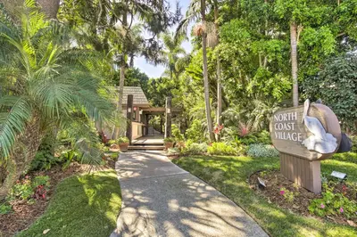 a garden path with a sign that says out cut out village at Charming Oceanside Condo with Beach and Pool Access! in Oceanside
