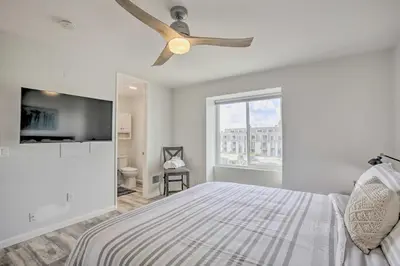 a bedroom with a bed and a ceiling fan at Charming Oceanside Condo with Beach and Pool Access! in Oceanside