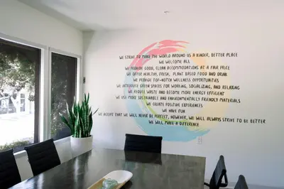 a dining room with a table with a quote on the wall at SCP Seven4One Hotel in Laguna Beach