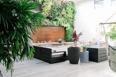 a living room with a fireplace and plants at SCP Seven4One Hotel in Laguna Beach
