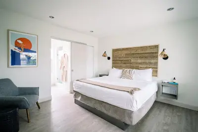 a bedroom with a large bed and a chair at SCP Seven4One Hotel in Laguna Beach