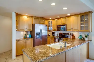 a kitchen with wooden cabinets and a stainless steel refrigerator at Cohasset Getaway Unit #3 in San Diego