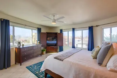 a bedroom with a large bed with blue curtains at Cohasset Getaway Unit #3 in San Diego