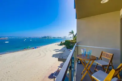 a balcony with a table and chairs and a beach at Cohasset Getaway Unit #3 in San Diego