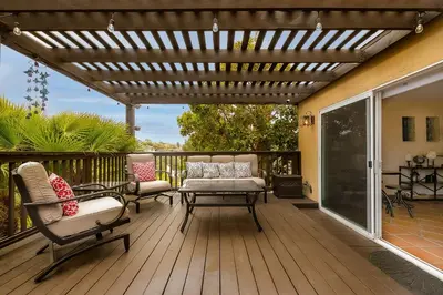 a pergola on a deck with chairs and a table at Canyon Palms in San Diego