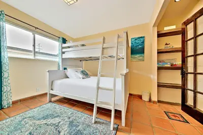 a bedroom with a bunk bed with a ladder at Canyon Palms in San Diego
