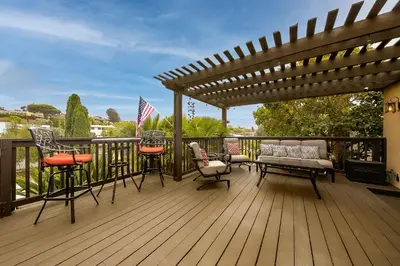 a wooden deck with chairs and a pergola at Canyon Palms in San Diego