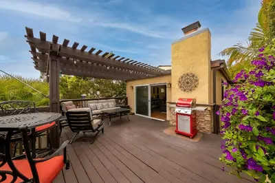 a wooden deck with a table and chairs and a pergola at Canyon Palms in San Diego