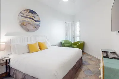 a bedroom with a large white bed with yellow pillows at Santa Barbara Unit #2 in San Diego