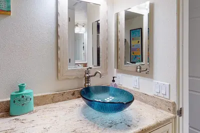 a bathroom with a blue bowl sink and mirrors at Santa Barbara Unit #2 in San Diego