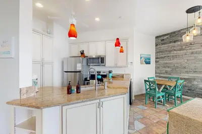a kitchen with white cabinets and a table with chairs at Santa Barbara Unit #2 in San Diego