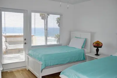 a bedroom with two beds and a window at The Bridge At South Oceanside is the Perfect Family Beach House now with AC in Oceanside