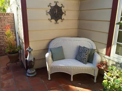 a white wicker chair sitting on a porch at Coastal Hideaway in Carlsbad