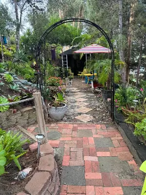 a garden with an arch and a patio with plants at Coastal Hideaway in Carlsbad