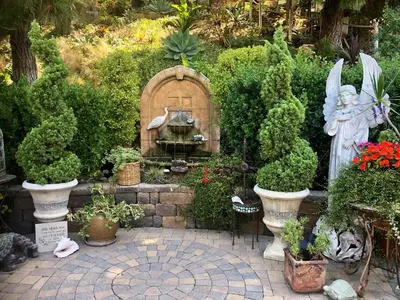 a garden with a statue and a fountain with plants at Coastal Hideaway in Carlsbad