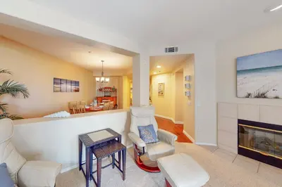 a living room with a fireplace and white furniture at Ocean Pointe Lagoon 107 - 30 Night Minimum in Carlsbad
