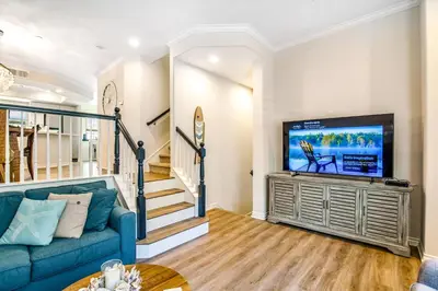 a living room with a blue couch and a flat screen tv at Carlsbad Village Charm in Carlsbad