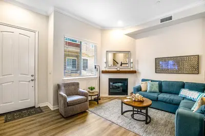 a living room with a blue couch and a chair at Carlsbad Village Charm in Carlsbad