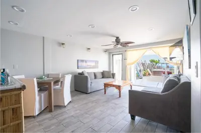 a living room with a couch and a table at BEACHFRONT COTTAGE LOWER UNIT in Oceanside