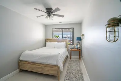 a bedroom with a bed and a ceiling fan at BEACHFRONT COTTAGE LOWER UNIT in Oceanside