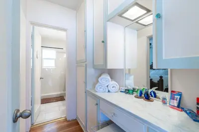 a bathroom counter with a sink and a mirror at BEACHFRONT COTTAGE UPPER UNIT in Oceanside
