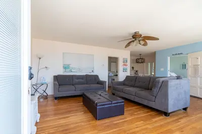 a living room with two couches and a ceiling fan at BEACHFRONT COTTAGE UPPER UNIT in Oceanside