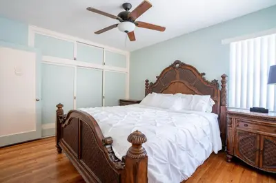 a bedroom with a bed and a ceiling fan at BEACHFRONT COTTAGE UPPER UNIT in Oceanside