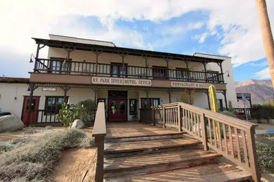 a building with a wooden staircase in front of a building at Palm Canyon Hotel and RV Resort in Borrego Springs