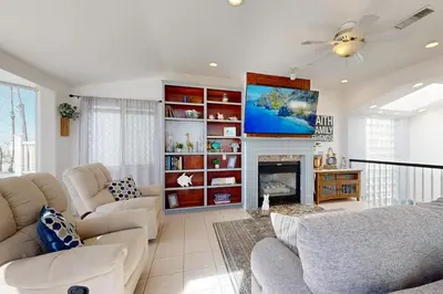 a living room with a couch and a tv at The Strand Oasis in Oceanside