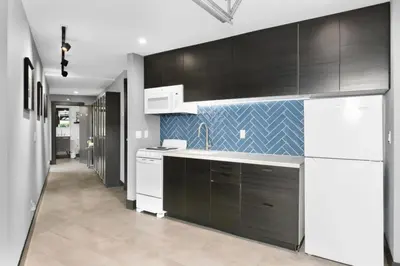 a kitchen with black cabinets and white appliances at Contemporary Ocean Sunset Views with Firepit Pt Loma close to PLNU in San Diego