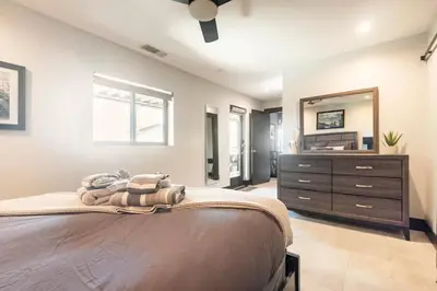 a bedroom with a bed and a dresser with a mirror at Contemporary Ocean Sunset Views with Firepit Pt Loma close to PLNU in San Diego