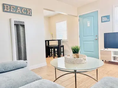 a living room with a couch and a table and a tv at Cozy Beach Cottage with Bicycles in San Diego